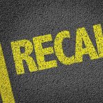 Yellow RECALL text on asphalt background.