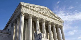 Supreme Court building with statue and columns.