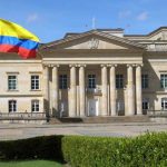 Historic building with Colombia flag in front.