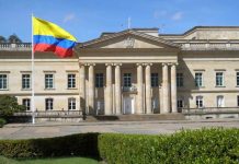 Historic building with Colombia flag in front.