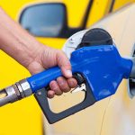 Stealth Gas INCREASE Hit 19 States! A person refueling a car at a gas station with a blue nozzle