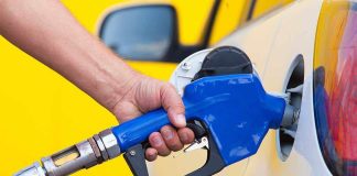 Stealth Gas INCREASE Hit 19 States! A person refueling a car at a gas station with a blue nozzle