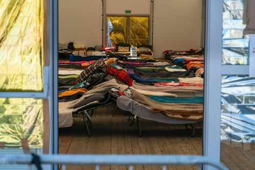 Interior view of a temporary shelter with rows of beds.