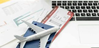 Four Letters You DON’T Want To See on Your Flight Ticket! A model airplane on a blue passport next to a laptop and boarding pass