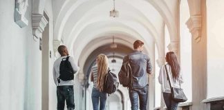 University Campus Armories Exposed! Four students walking in a corridor together.