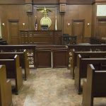 State Makes One Crime AUTOMATIC Death Penalty! Interior view of an empty courtroom with wooden benches and a judges bench