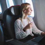 Airline Considers Child-Free Flights Passenger with headphones seated by airplane window