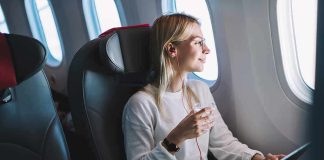 Airline Considers Child-Free Flights Passenger with headphones seated by airplane window