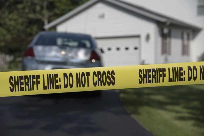shutterstock_453232906 Sheriff line tape blocking a suburban driveway