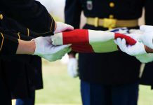 Military personnel folding a flag during a ceremonial event