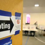 Voting sign on door leading to polling place