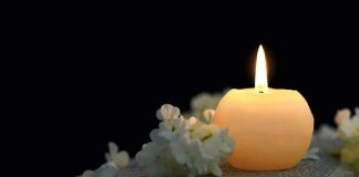 TV Star-Turned-Congressman Dies Aged 84 Candle on an open book with white flowers