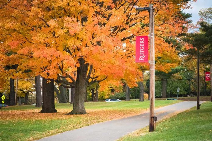 shutterstock_1222049767 Autumn trees along a campus pathway with red banners on poles