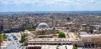 historic mosque with domes and minaret overlooking a busy city square