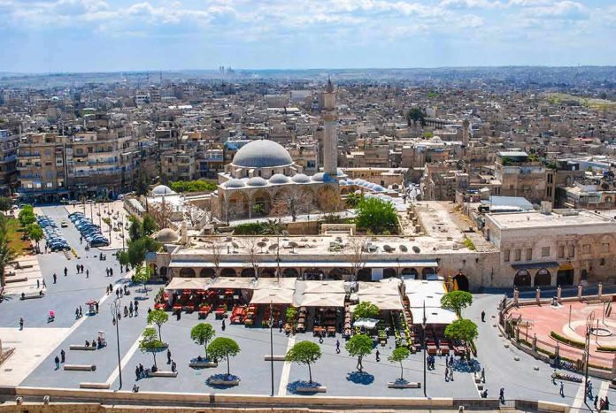 historic mosque with domes and minaret overlooking a busy city square