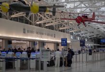 airport security checkpoint with passengers and hanging vintage airplanes