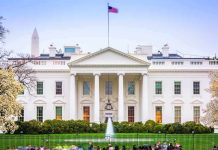 The White House facade with fountain and flag