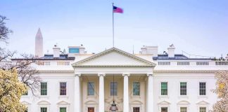 The White House facade with fountain and flag