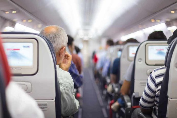 shutterstock_256478011 Airplane cabin aisle with passengers seated and seatback screens