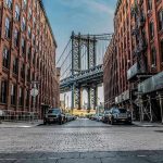 4 Kids GUNNED DOWN In July 4th Massacre! Street view with bridge between two brick buildings.