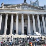 Reporters and photographers gathered outside a neoclassical courthouse