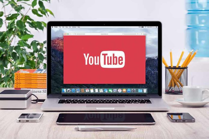293731811-2 YouTube logo on a laptop screen on desk.