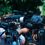Air Force One Stuck on Tarmac After Bizarre Incident TV news cameras crowding together at an outdoor event
