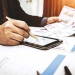 Trump Made Over 3,700 Trades in 3 Months! Businessperson analyzing charts with tablet and papers