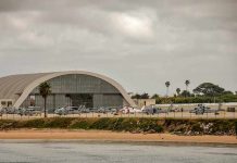 airport hangar with helicopters near a shoreline