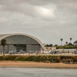 airport hangar with helicopters near a shoreline