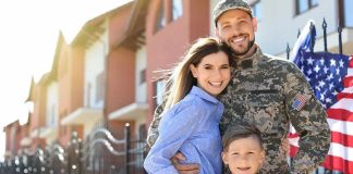 Military family posing together outside a suburban home
