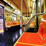 Empty subway car with orange seats and open doors