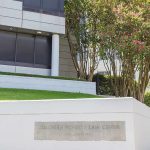 Civil Rights Boss Sent $1.2 Million to Neo-Nazi Lover! Modern office building with landscaped lawn and flowering trees