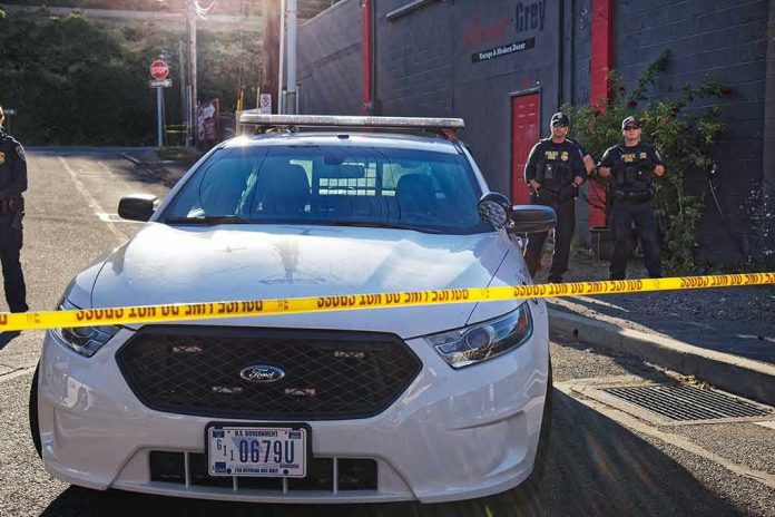 Aaron Guiel near police car behind yellow caution tape