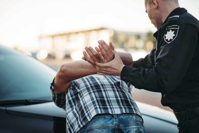 Police officer detains person against car