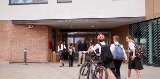 Students in uniforms arriving at a school entrance