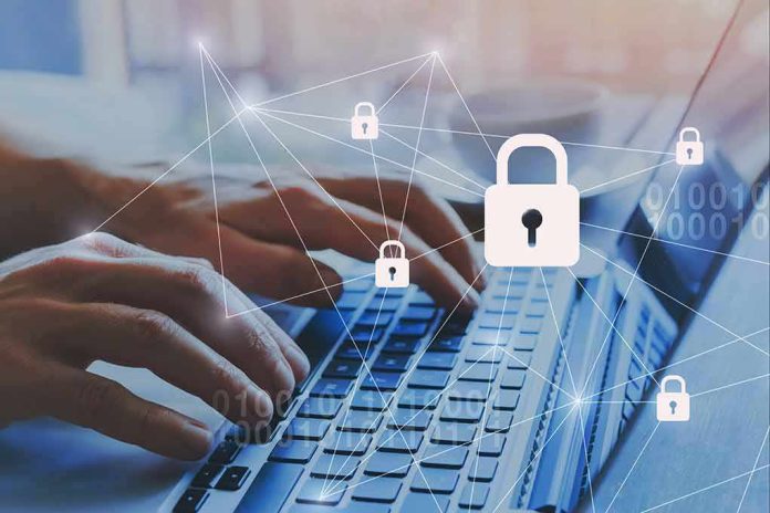shutterstock_1202221816 Hands typing on laptop with digital padlock icons overlay
