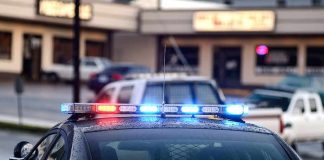 Police car with flashing red and blue lights in a parking lot