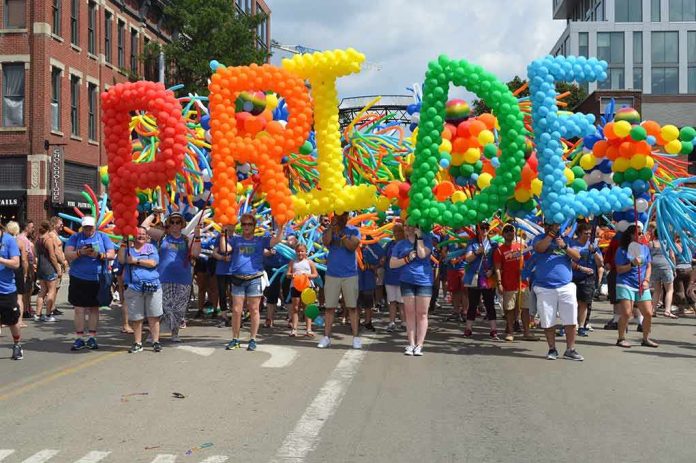 shutterstock_1271177443 Dontrelle Inman at a Pride parade holding balloon letters spelling PRIDE