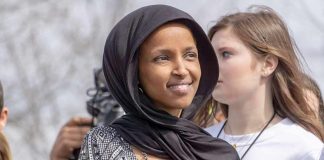 Ilhan Omar wearing a black headscarf at an outdoor event