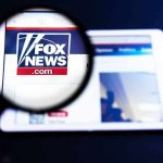 Magnifying glass over Fox News website logo on a tablet