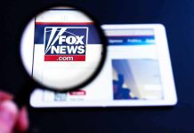 Magnifying glass over Fox News website logo on a tablet