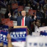 Donald Trump speaks at a rally, giving two thumbs up