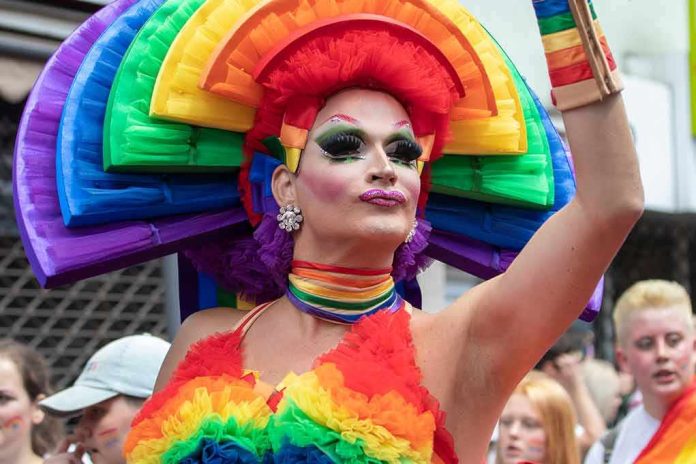 shutterstock_1451344577 Drag performer in vibrant rainbow costume at a parade