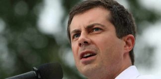 Pete Buttigieg speaking into a microphone outdoors