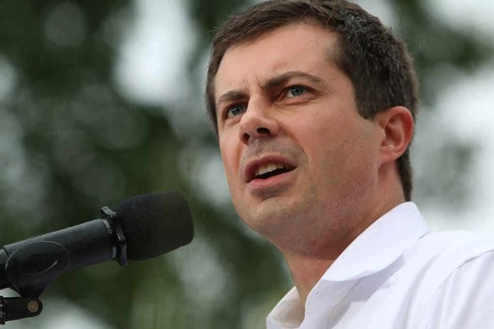 Pete Buttigieg speaking into a microphone outdoors
