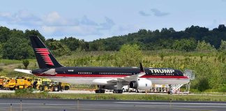Private jet with black and red livery parked on airport tarmac