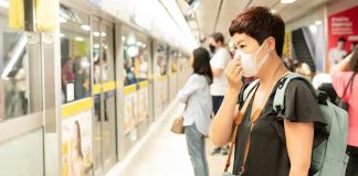 Woman wearing a face mask waiting on a subway platform
