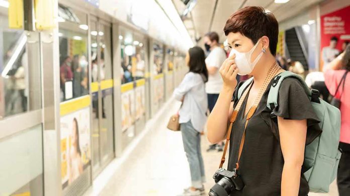Woman wearing a face mask waiting on a subway platform