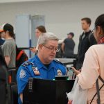 Bill Bergey, a TSA officer, checks a traveler's documents at an airport security checkpoint